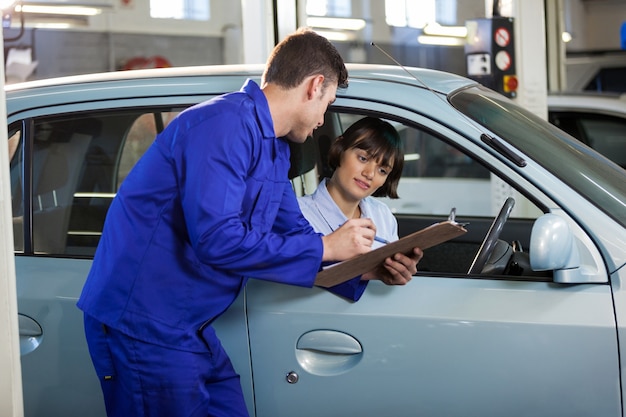 Gratis foto mechanic met de offerte aan een klant