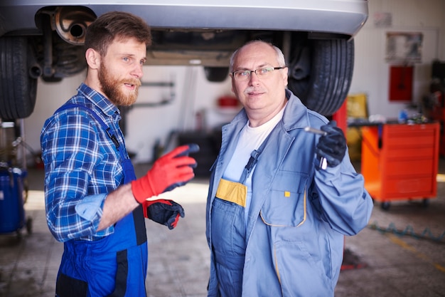 Mechanica die een auto in de werkplaats herstelt