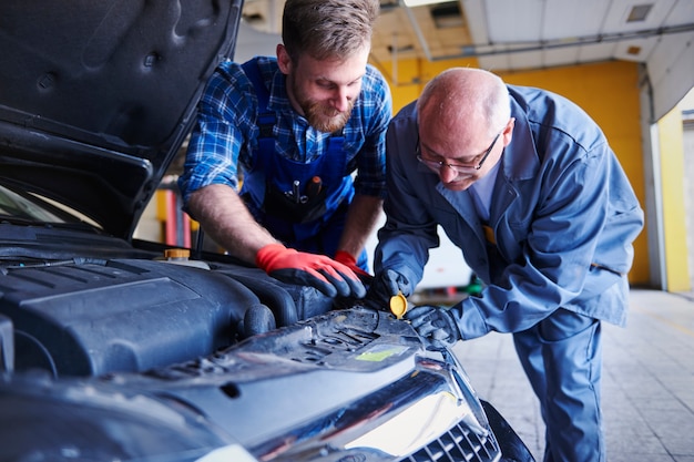 Mechanica die een auto in de werkplaats herstelt