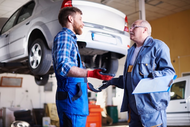 Mechanica die een auto in de werkplaats herstelt