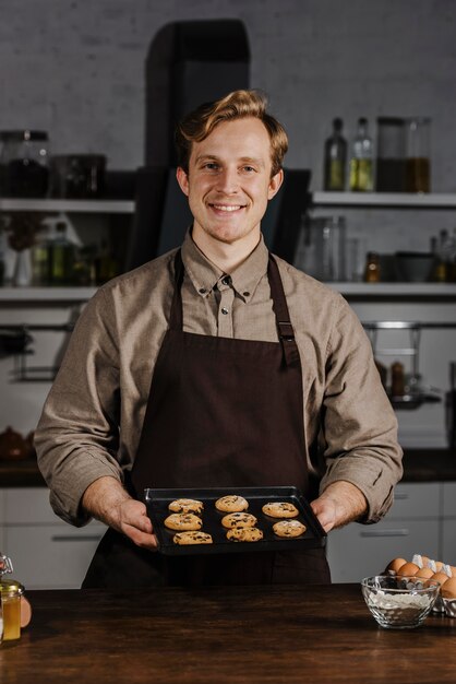 Medio geschoten dienblad van de chef-kokholding met koekjes