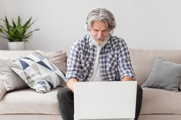 Medio geschotene leraar die aan laptop werkt