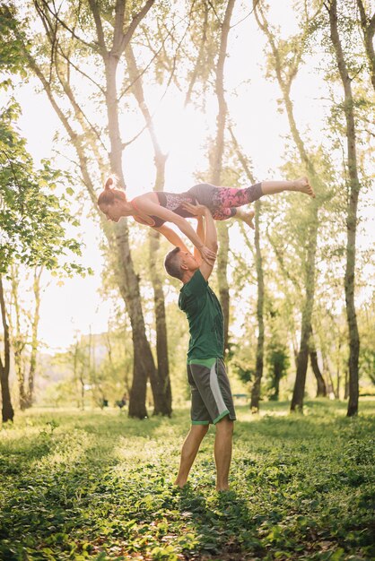 Medio volwassen paar dat acrobatische trucs in park gebruikt
