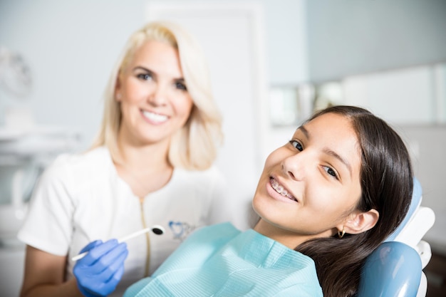 Medio volwassen tandarts met patiënt bij tandheelkundige kliniek