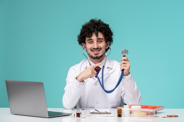 Medisch op afstand bezig met computer schattige knappe dokter in laboratoriumjas glimlachend met stethoscoop