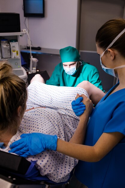 Medisch team dat zwangere vrouw onderzoekt tijdens levering