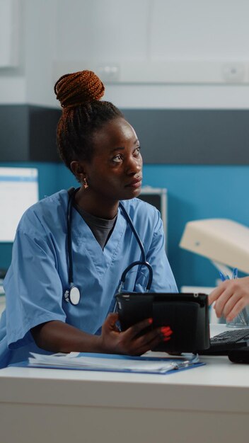 Medisch team van verpleegkundigen met behulp van tablet met touchscreen in kast voor onderzoek en afspraken. Groep assistenten die werken met technologie en apparatuur voor gezondheidszorg en behandeling