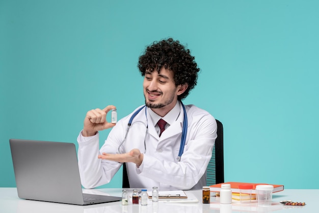 Medische schattige knappe dokter die op afstand op de computer werkt in een laboratoriumjas met medicatie