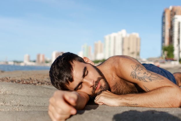 Gratis foto medium geschoten man met harige borst aan zee