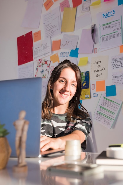 Gratis foto medium geschoten smileyvrouw bij bureau