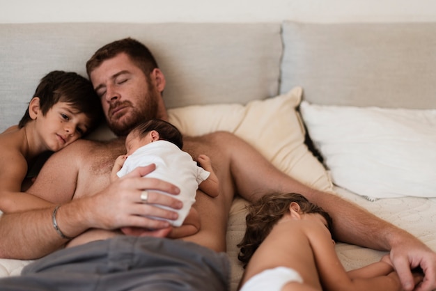 Gratis foto medium geschoten vader met zijn kinderen in bed