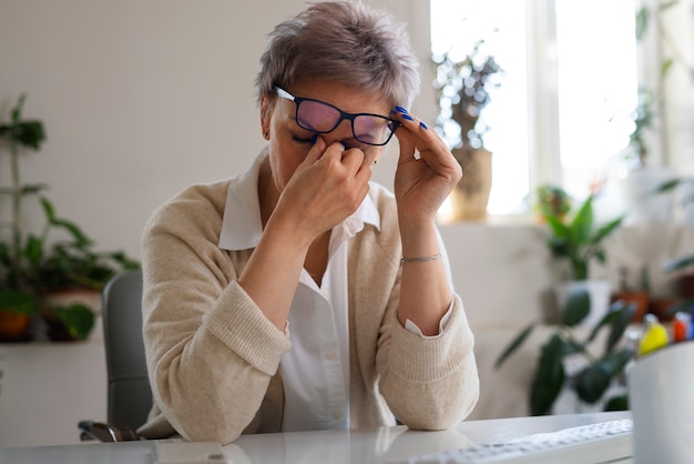 Gratis foto medium geschoten vrouw zittend aan een bureau