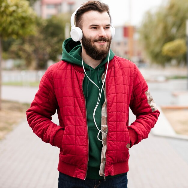 Medium geschotene smileykerel met baard en hoofdtelefoons