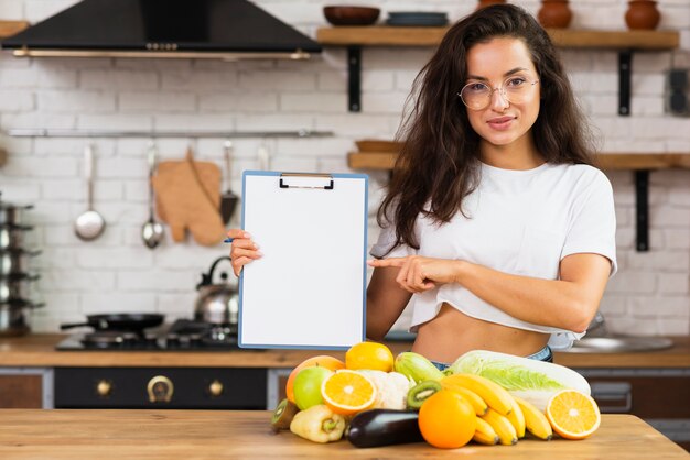 Medium geschotene smileyvrouw in de keuken