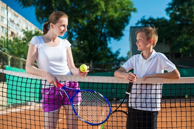 Medium geschotene vrouw met jong geitje speeltennis