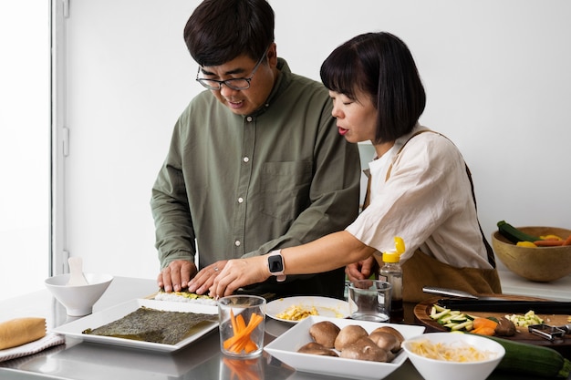 Gratis foto medium shot aziatisch stel koken