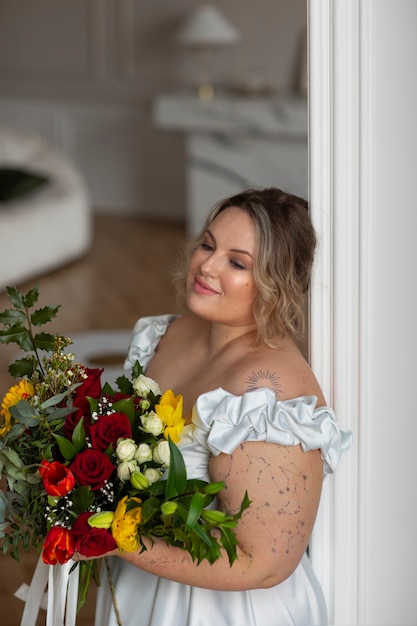 Medium shot bruid poserend met bloemen