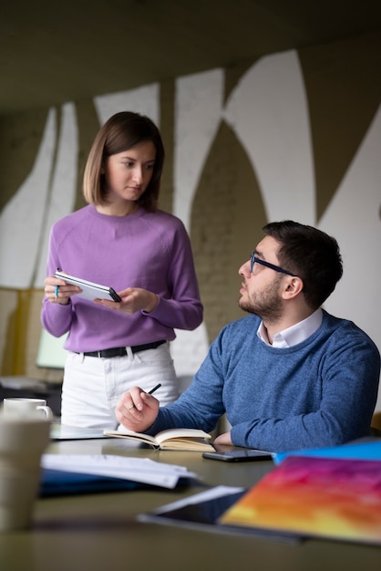 Medium shot collega's debatteren op het werk