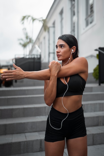 Medium shot fitte vrouw die buiten traint