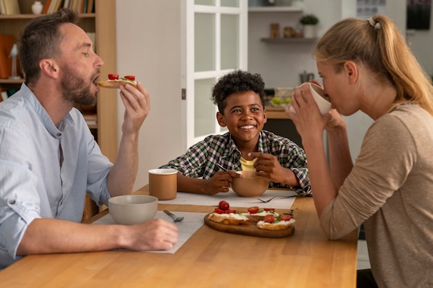 Gratis foto medium shot gelukkige familie die samen eet