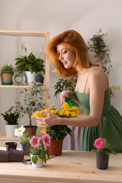 Medium shot gelukkige vrouw die bloem water geeft