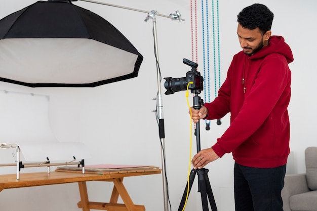 Medium shot gespecialiseerde fotograaf die in de studio werkt