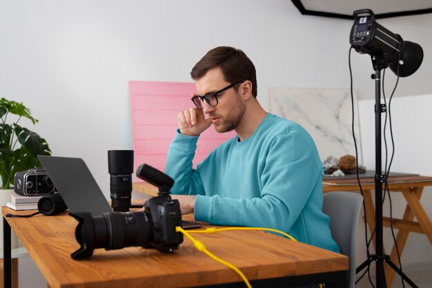 Medium shot gespecialiseerde fotograaf die in de studio werkt