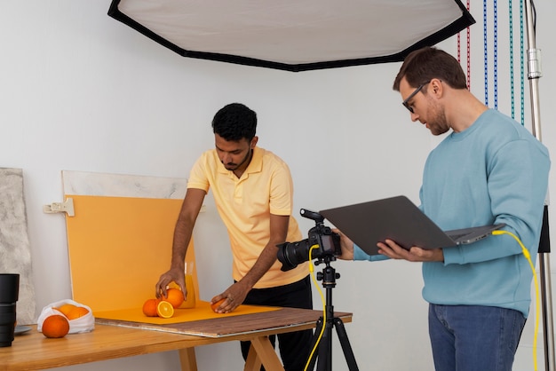 Gratis foto medium shot gespecialiseerde fotografen die in de studio werken