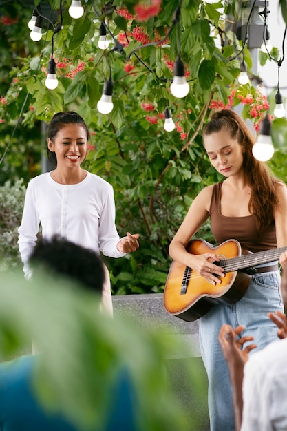 Medium shot getalenteerde vrouw die gitaar speelt