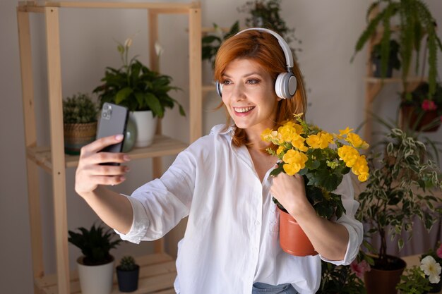 Medium shot glimlachende vrouw die een selfie maakt.
