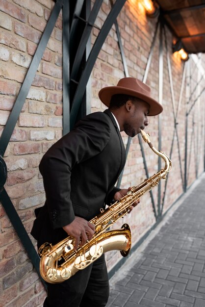 Medium shot jonge man die saxofoon speelt