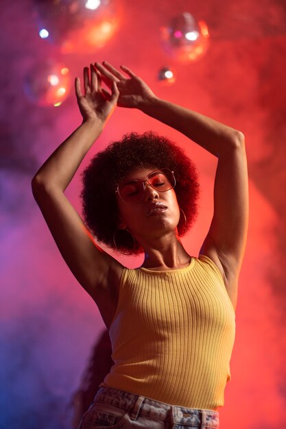 Medium shot jonge vrouw die danst op een techno feestje