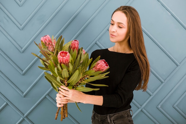 Medium shot jonge vrouw poseren met bloemen