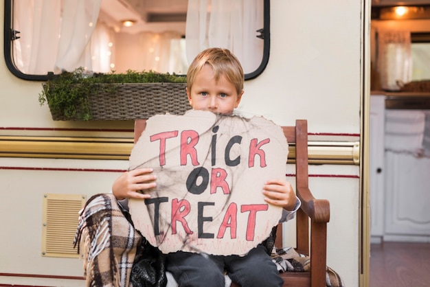 Medium shot jongen met trick or treat-teken