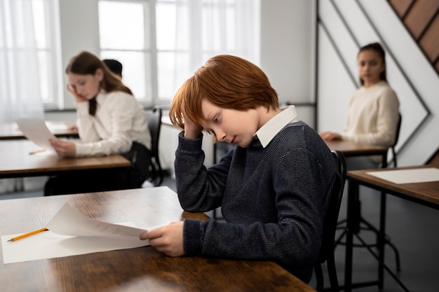 Gratis foto medium shot kind spiekt op schooltoets