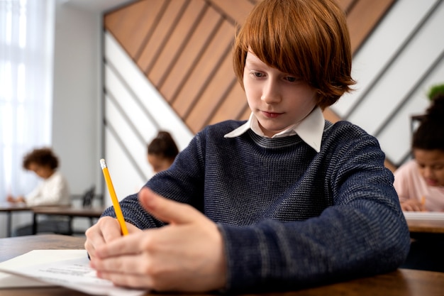 Gratis foto medium shot kind spiekt op schooltoets