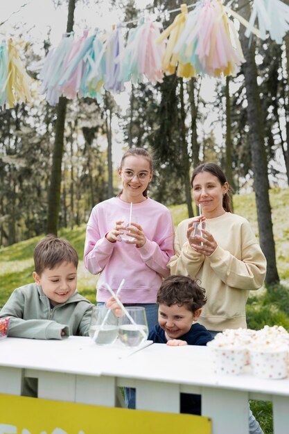 Medium shot kinderen die buiten limonade drinken