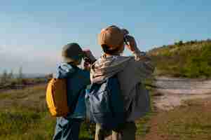 Gratis foto medium shot kinderen die de natuurlijke omgeving verkennen