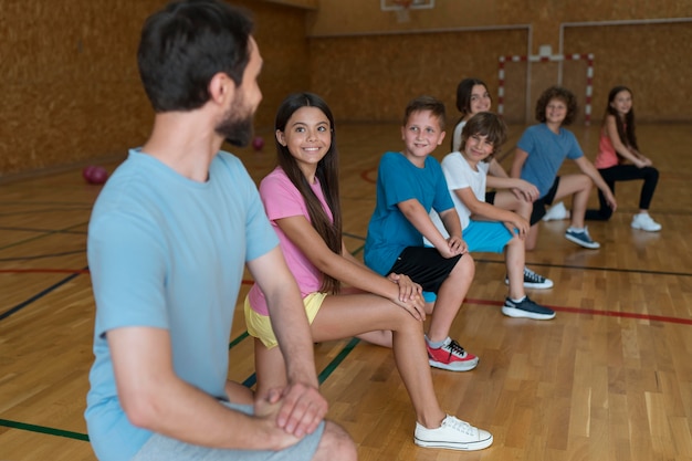 Medium shot kinderen die sporten in de sportschool