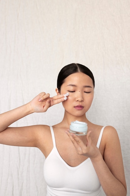 Medium shot Koreaanse vrouw poseren met gezichtscrème