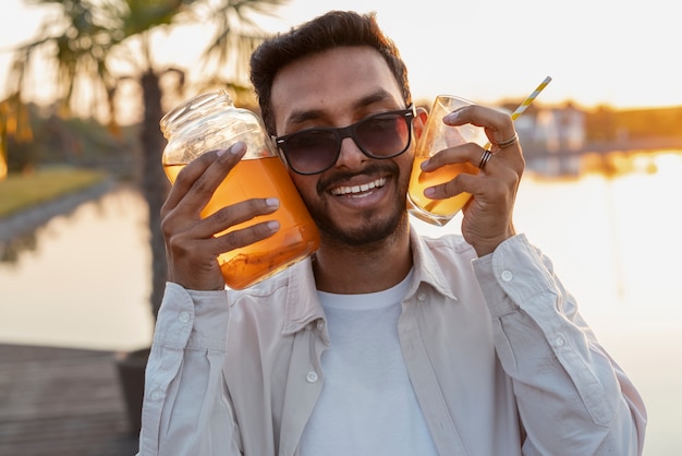 Gratis foto medium shot man met heerlijke kombucha buiten