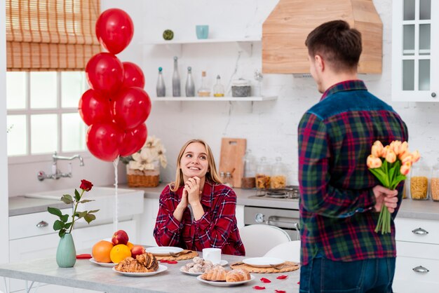 Medium shot man verrassende vrouw met bloemen