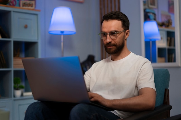 Medium shot man werkt aan een laptop.