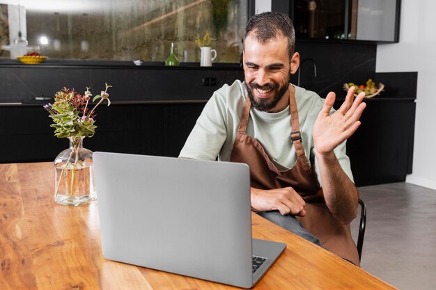 Medium shot man zwaaien naar laptop