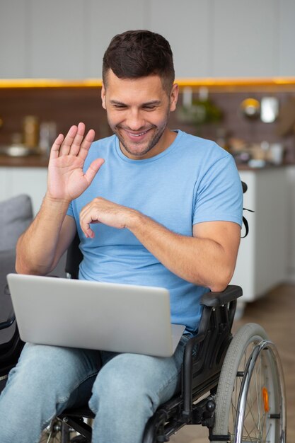 Medium shot man zwaaiend naar laptop