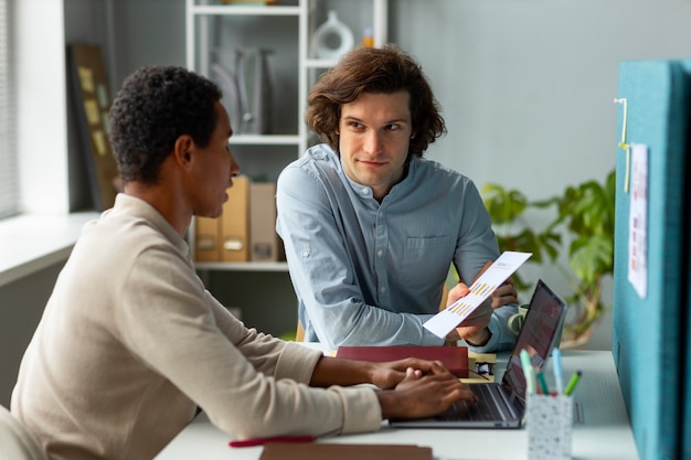 Gratis foto medium shot mannen bespreken op het werk