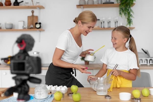 Medium shot meisje en vrouw die voedsel bereiden