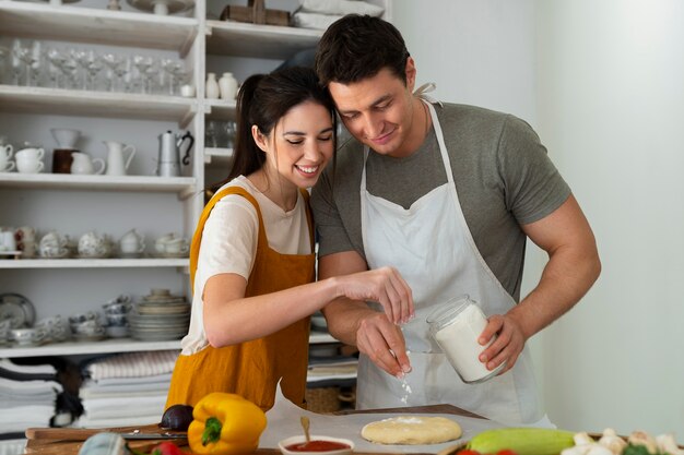 Medium shot mensen die samen pizza koken