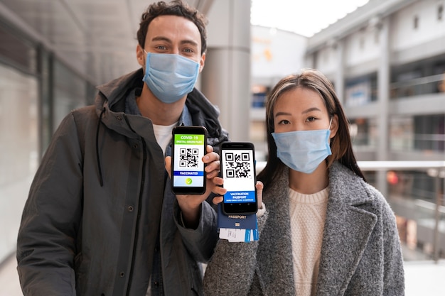 Medium shot mensen met gezondheidspaspoorten en maskers