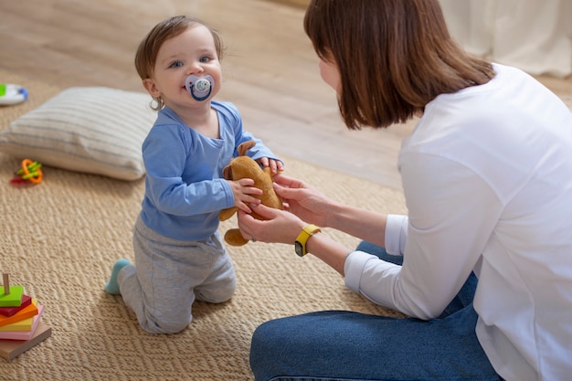 Gratis foto medium shot moeder en baby thuis